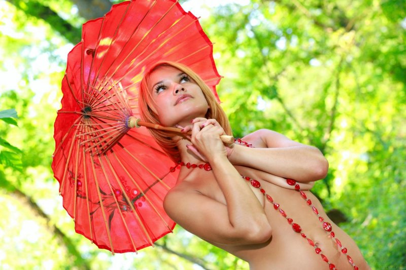 Голая девушка в красных чулках на природе