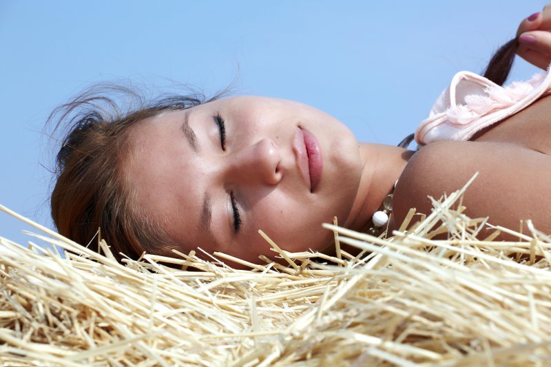 Голая девушка на сене с маленькой грудью и бритой щелкой